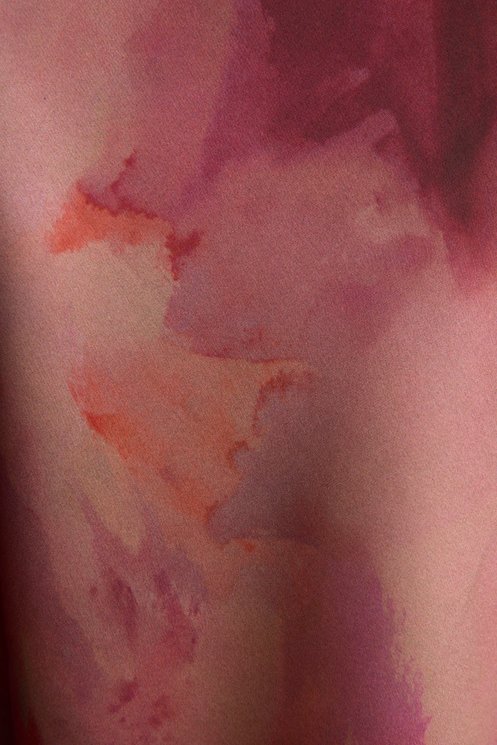 Close-up of berry blur watercolor print on satin maxi skirt fabric, pink and plum tones.