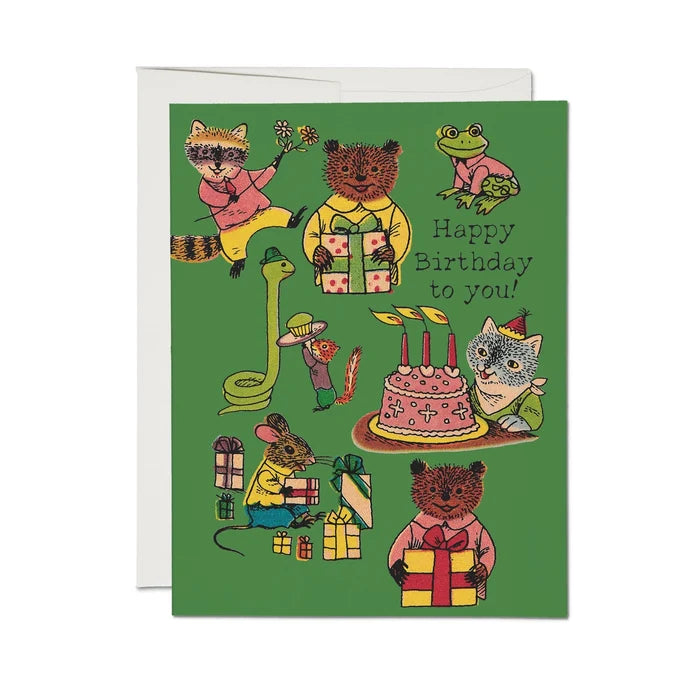 Birthday card with illustrated animals around a cake and presents on a green background