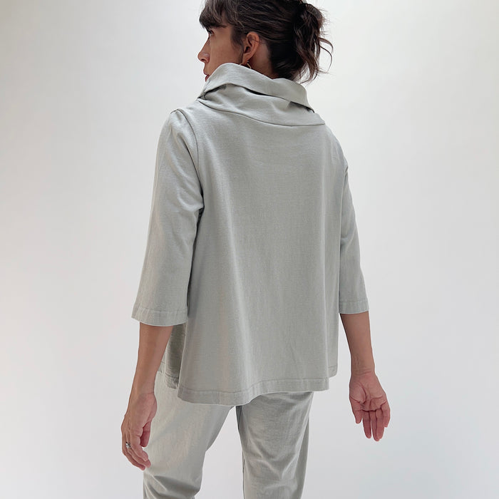Back view of model wearing Bryn Walker orlaya 3/4 sleeve Etta top, showing draped cowl at back neckline, boxy A-line silhouette, 3/4 sleeves, and banded hem