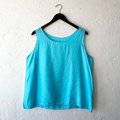 Blue tank top on a hanger against a white wall