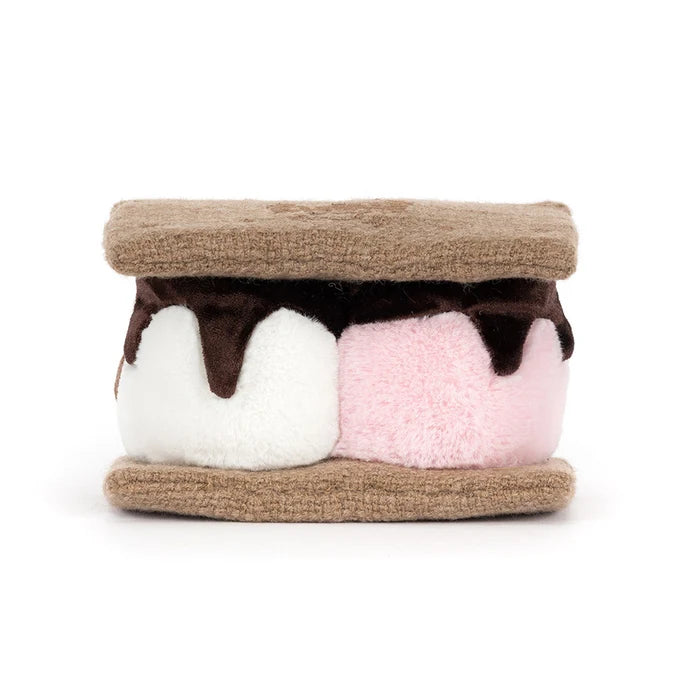 Toy resembling a s'more with brown, white, and pink layers on a white background as seen from behind