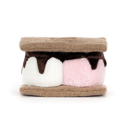 Toy resembling a s'more with brown, white, and pink layers on a white background as seen from behind
