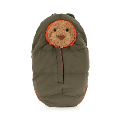 Plush toy with bear face shown wrapped inside a sleeping bag on a white background