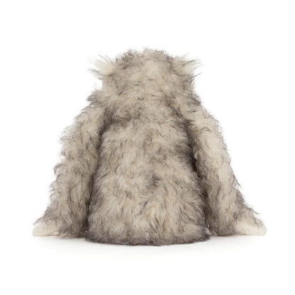 Plush toy resembling a yeti on a white background as seen from behind
