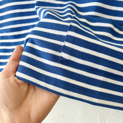 Close-up of a hand holding a blue and white striped fabric