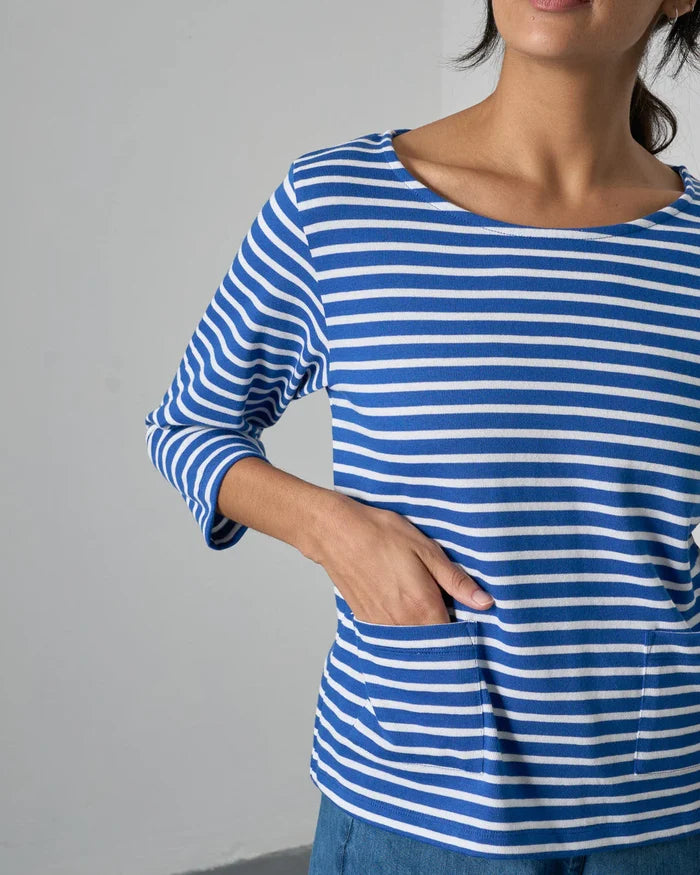 Person wearing a blue and white striped shirt against a gray background