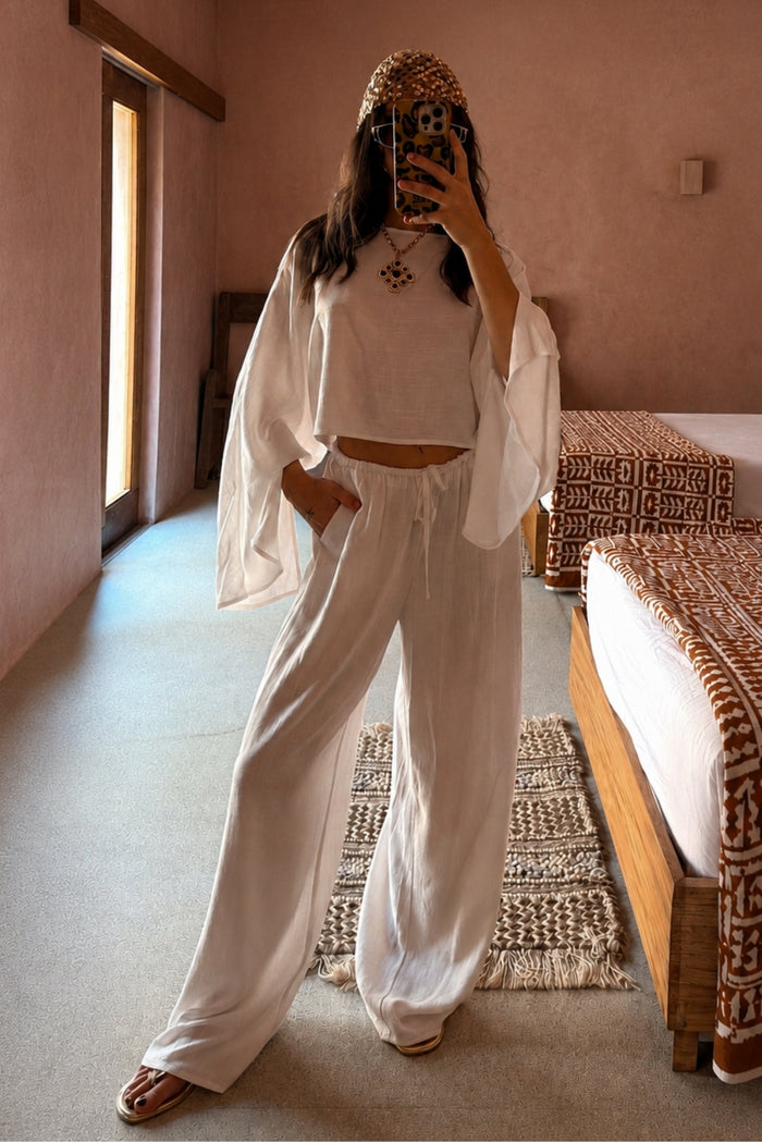 Clear Breeze white linen pants and matching top worn in a terracotta resort bedroom.