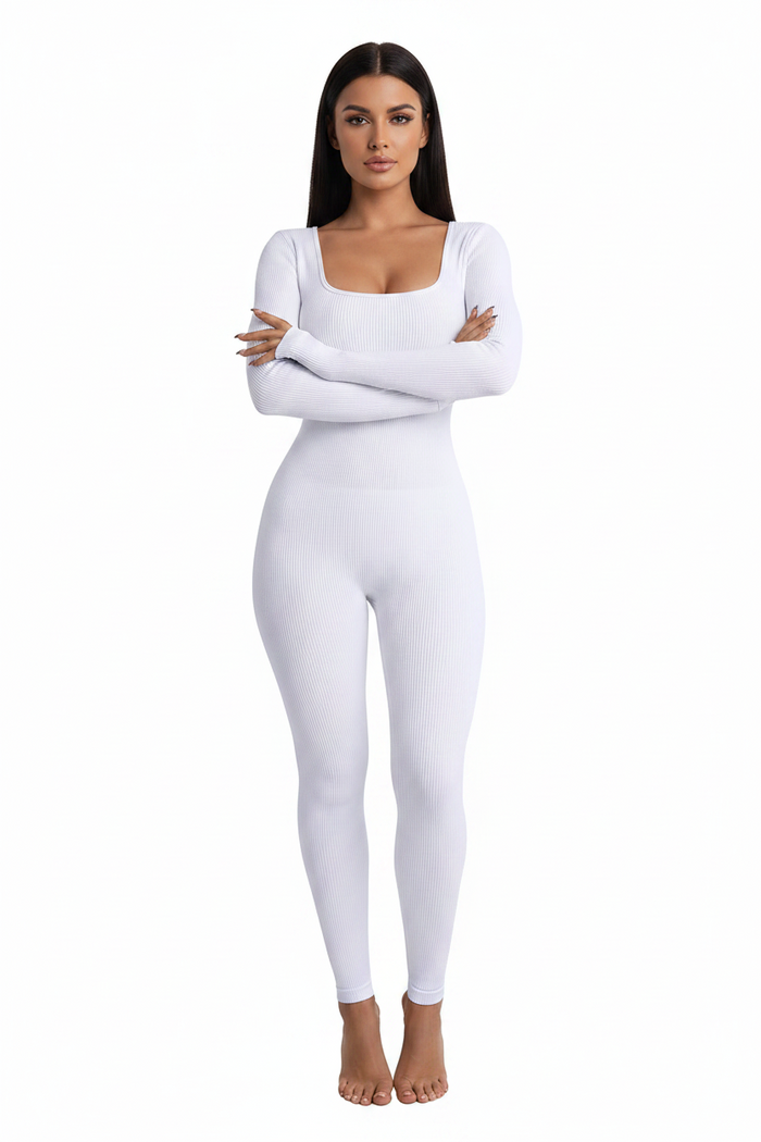 Model posing in a purple bodycon cotton jumpsuit with long sleeves, styled with a mini bag for evening wear.