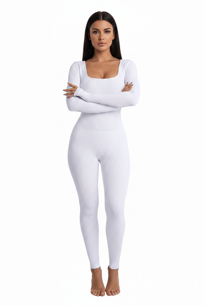 Model posing in a purple bodycon cotton jumpsuit with long sleeves, styled with a mini bag for evening wear.