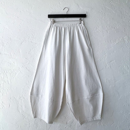 Pacific Cotton cream Oliver pant on hanger, front view showing elastic waistband, wide balloon-leg silhouette, patch panels at hem, and full length