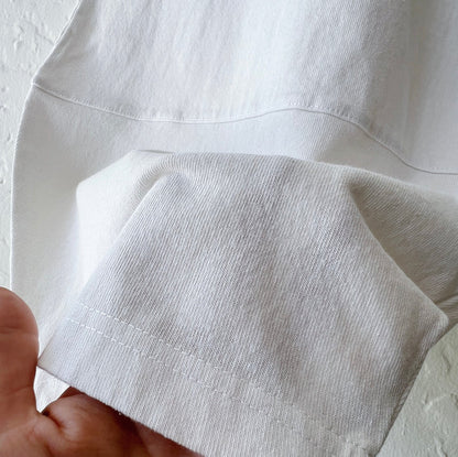 Close-up detail of Pacific Cotton cream Oliver pant hem, showing curved patch panel construction and cotton fabric texture