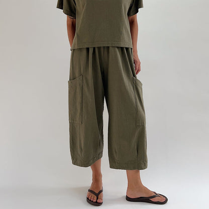 Full front view of model wearing Bryn Walker jasper Pasha pant, showing both large patch pockets, relaxed wide-leg fit, elastic waist, and banded capri hem