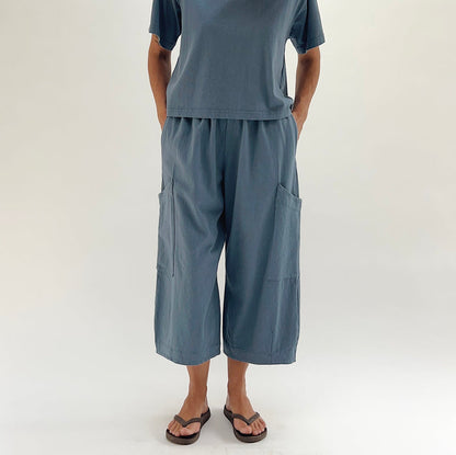 Full front view of model wearing Bryn Walker vitznau cotton Pasha pant, showing both large patch pockets, elastic waistband, wide cropped leg silhouette, and straight hem