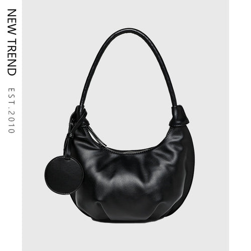 Dumpling shoulder bag with curved silhouette, PU leather exterior, zipper closure and single strap for casual outfit styling.