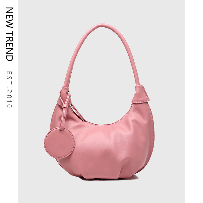 Brown crescent shoulder bag with PU leather exterior, zipper closure, one strap and a curved silhouette for daily outfit use.