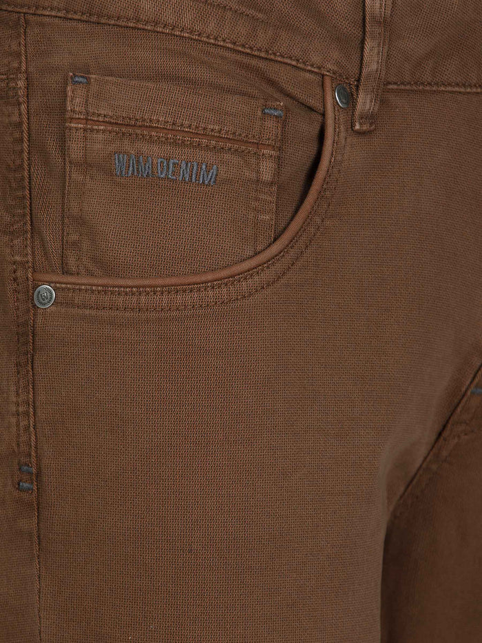 Close-up of brown jeans hem with rugged denim texture. – Wam Denim.