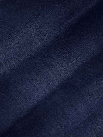 Close-up of dark navy denim fabric texture showing smooth weave and slight fade – Wam Denim.