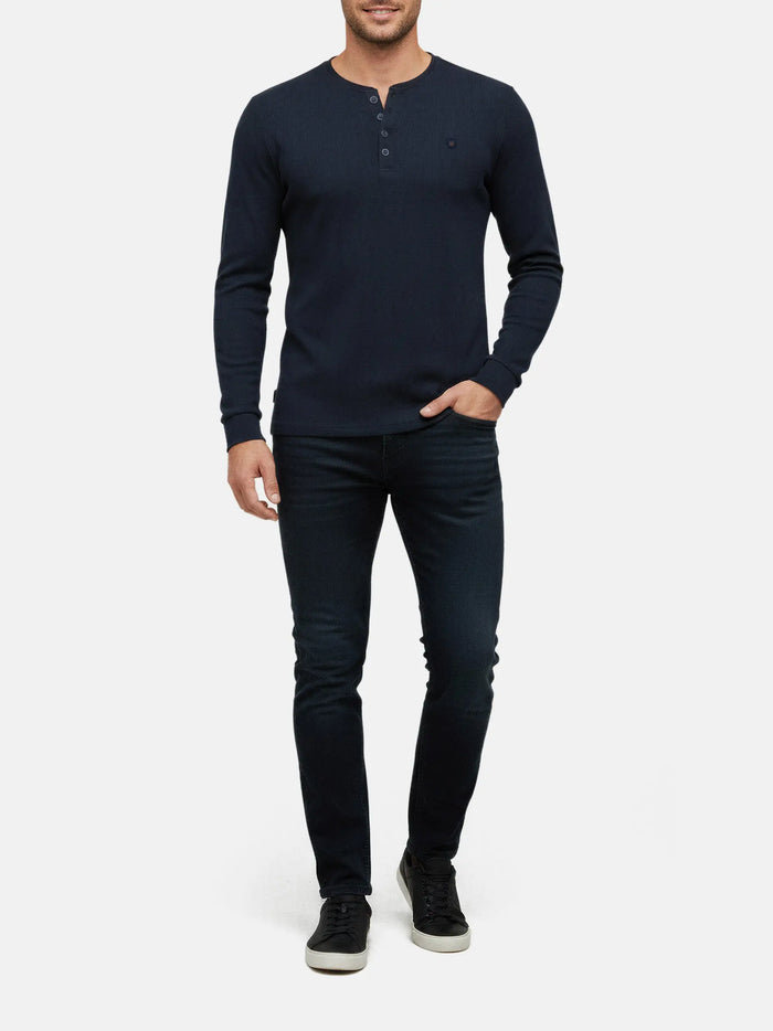 Model wearing navy long-sleeve men’s sweater with buttoned neckline, Zest Navy style.