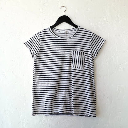 Navy and white striped t-shirt on a hanger against a white wall
