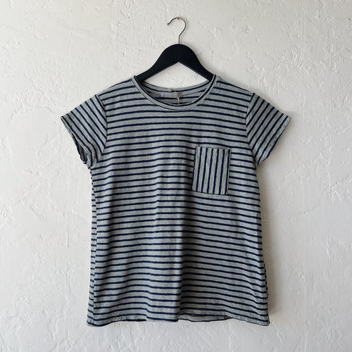 Striped t-shirt on a hanger against a white wall