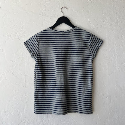 Striped t-shirt on a hanger against a white wall
