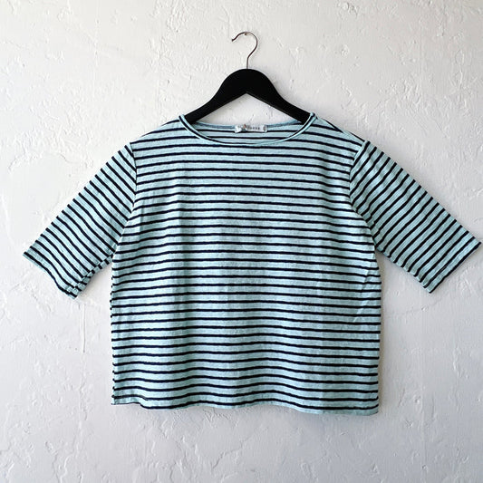 Striped shirt on a hanger against a white wall