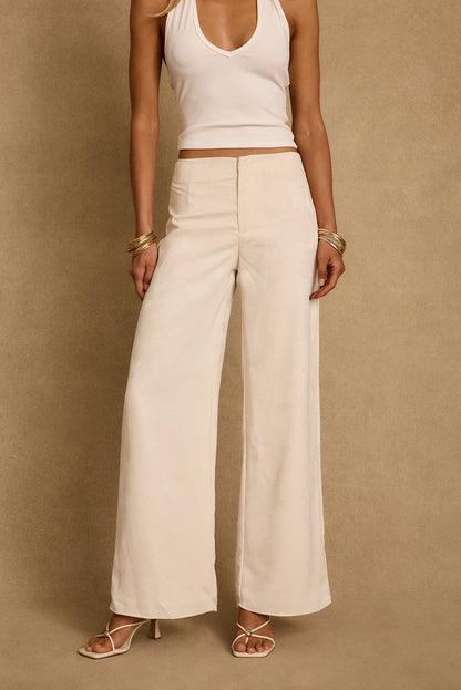 Ivory jacquard wide-leg trousers styled with a ribbed white tank and gold bangles.