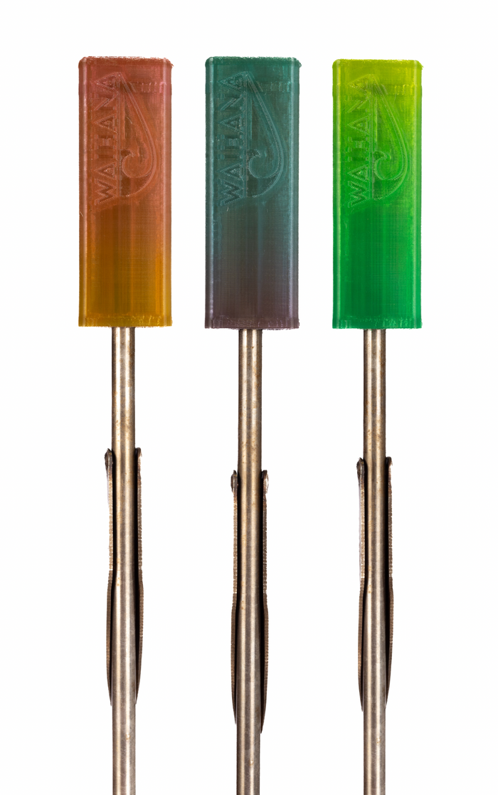 Three Waihana flexible spear tip protectors in orange, teal, and green gradient colorways mounted on stainless steel spear shafts with flopper tips, displayed against a white studio background.