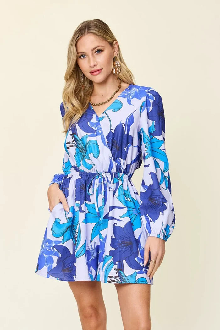 Women's romper option in Blue with a floral print, long sleeves, practical pockets and an opaque 100% polyester construction.