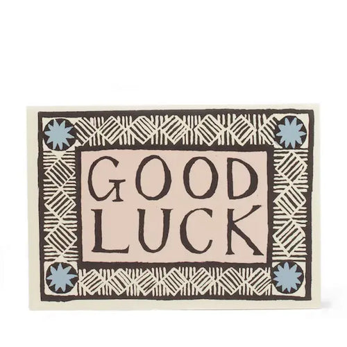 A greeting card with 'Good Luck' text in a decorative font, surrounded by a geometric pattern.