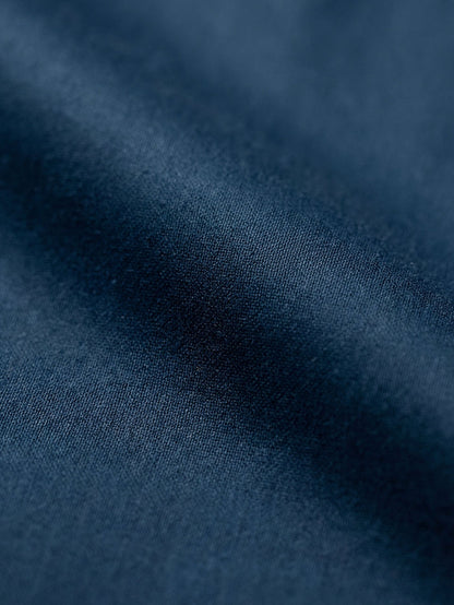 Close-up of petrol blue shirt fabric showing smooth texture and premium woven material.