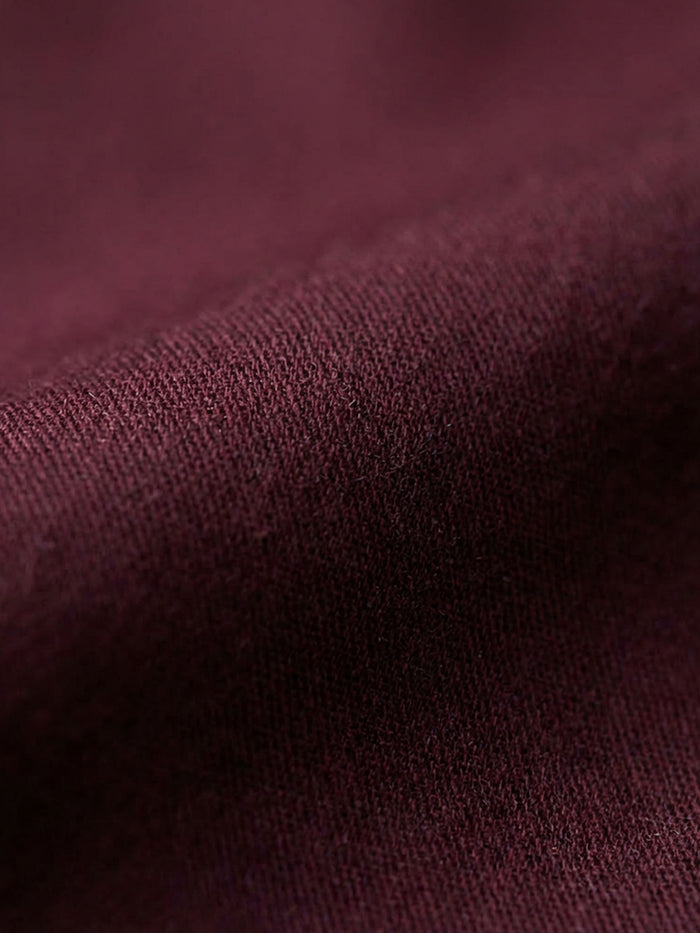 Close-up of dark red men’s shirt fabric showing smooth texture and premium weave