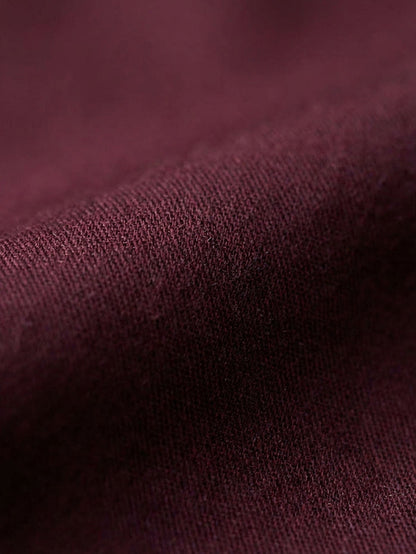 Close-up of dark red men’s shirt fabric showing smooth texture and premium weave