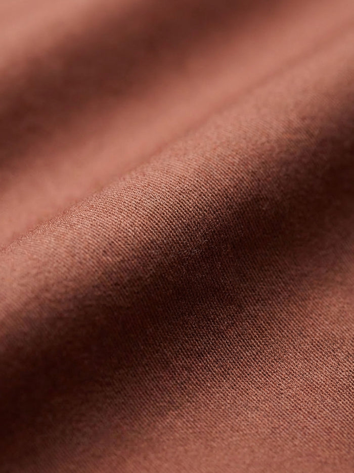 Close-up of light brown men’s shirt fabric showing smooth texture and premium weave