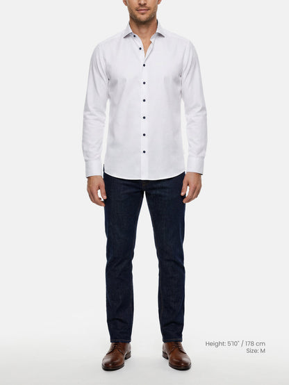 Model wearing white slim fit men’s dress shirt with dark buttons and jeans