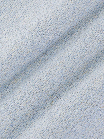 Close-up texture of blue fabric with a geometric pattern – Wam Denim.