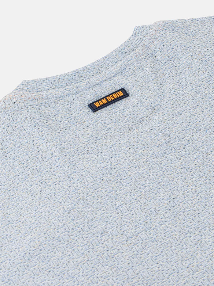 Close-up of the Wam Denim neck label on a blue marl t-shirt – Wam Denim.