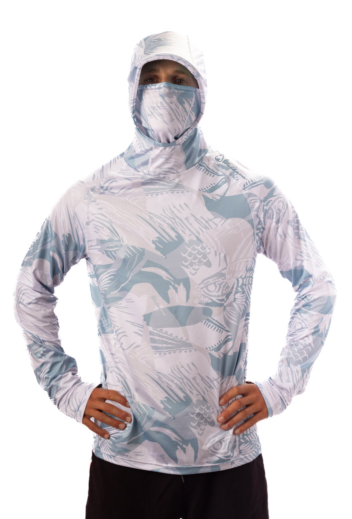 Male model wearing the Waihana Island Sky Fishbone Sun Shirt with full hood and integrated face mask pulled up, showcasing the light blue and white tropical fish print design.