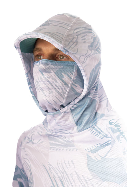Male model wearing the Waihana Island Sky Fishbone Sun Shirt with the built-in hood pulled up and face mask covering his nose and mouth, showcasing the light blue tropical print UPF protective fabric.