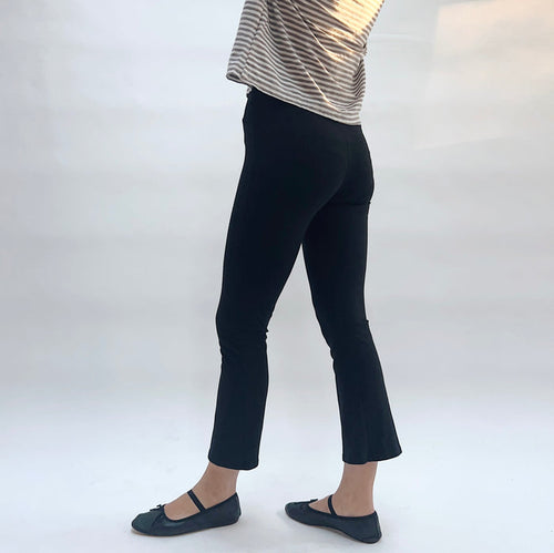 Person wearing black pants and a striped shirt on a white background
