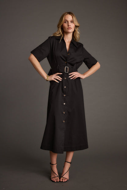 Full-length view of the black midi dress showing the drape and movement.