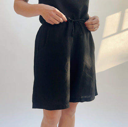 Person wearing black shorts against a plain background