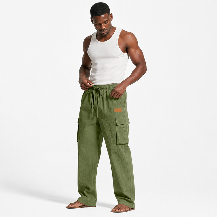 Men's cotton linen pants in army green shown on an adult male model adjusting the drawstring with cargo pockets clearly visible.