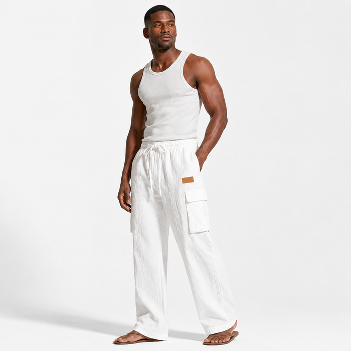 Men's cotton linen pants in white shown at a three-quarter angle on an adult male model with pockets and drawstring visible.