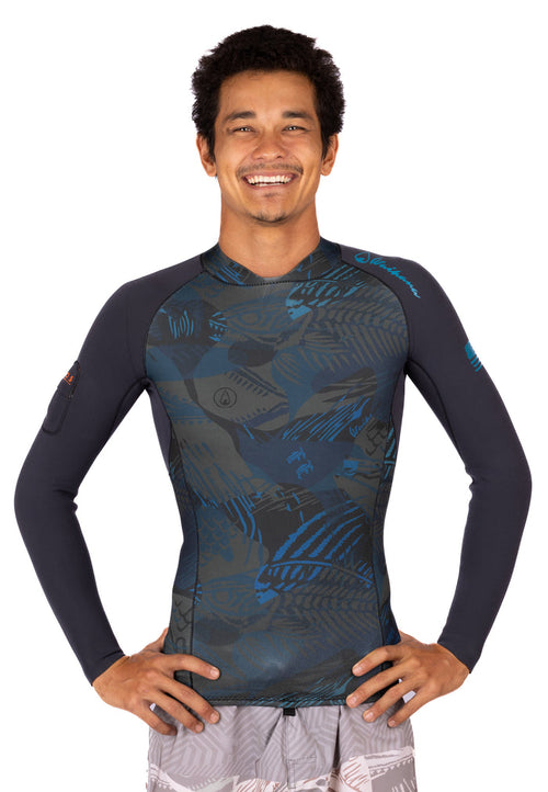 Smiling male model wearing the Waihana Men's Field Ethos Rear-zip Surf Rashguard in FE Blue, featuring a tropical camo print body and dark grey long sleeves, photographed against a white studio background.