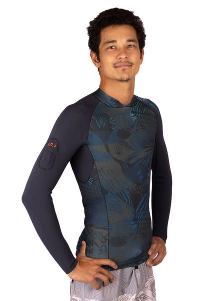 Male model wearing the Waihana Men's Field Ethos Rear-zip Surf Rashguard in blue tropical camo print with solid black long sleeves, shown from a three-quarter front view on a white studio background.