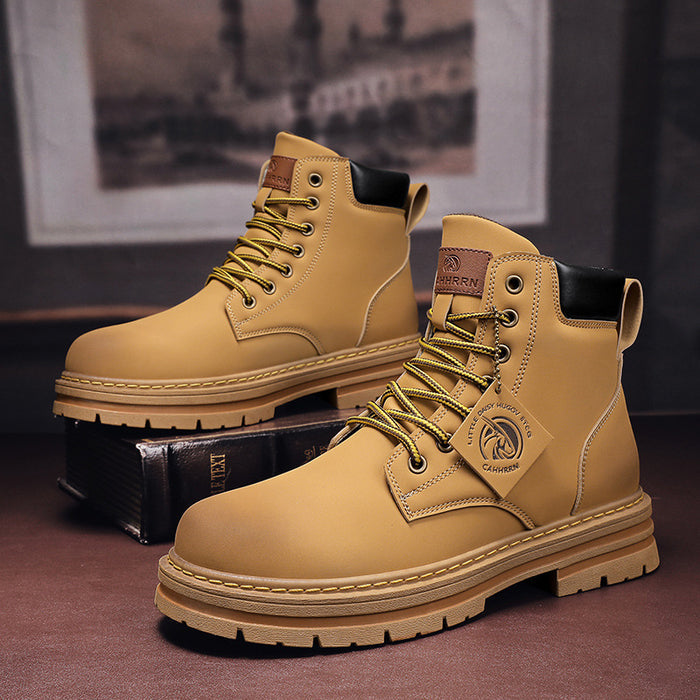 Pair of tan boots with a brand logo on a dark surface