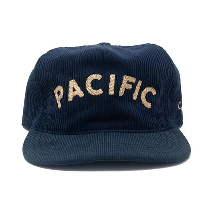 A dark navy blue corduroy baseball cap with 'PACIFIC' embroidered in beige across the front, shown against a plain white background.