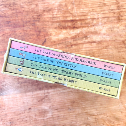 Set of children's books in a box with titles on a wooden surface
