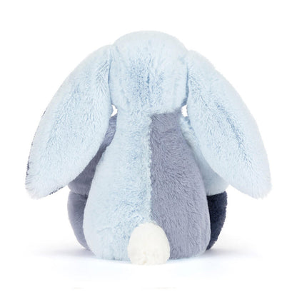 Plush toy rabbit with light blue and dark blue color scheme on a white background as seen from behind